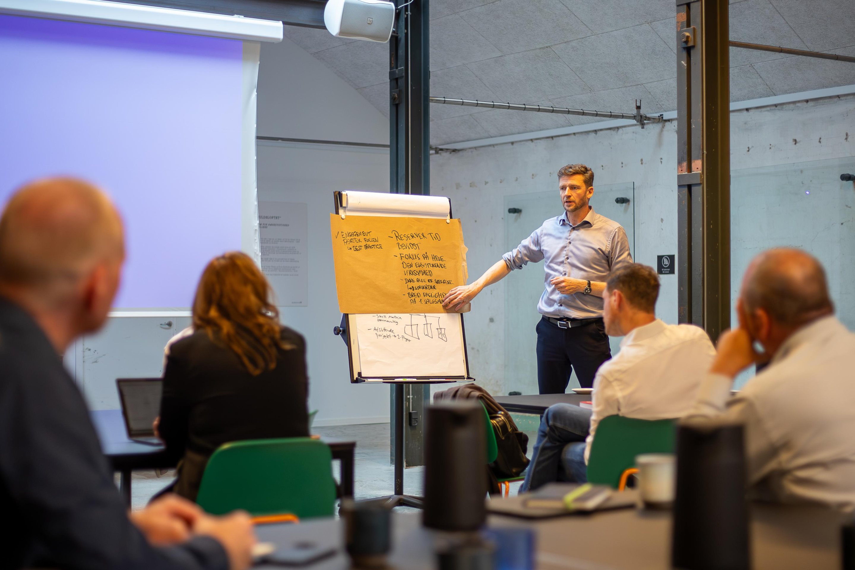 A ZILLION consultant walking colleagues through a flipchart in a workshop